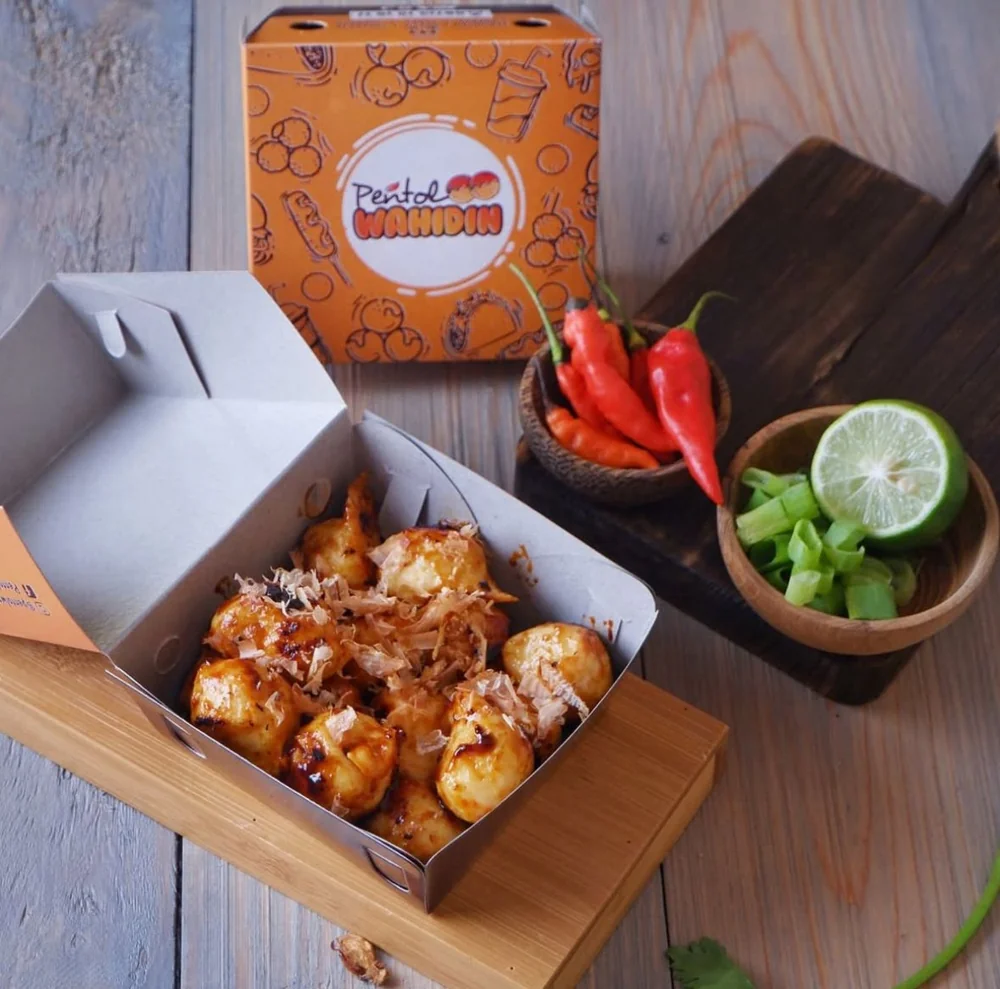 Pentol bakar Wahidin dengan saus dan taburan, disajikan dalam kotak